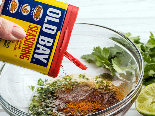 pouring old bay seasoning powder into a bowl