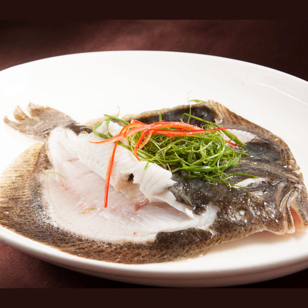 steamed turbot on white plate showing white meat
